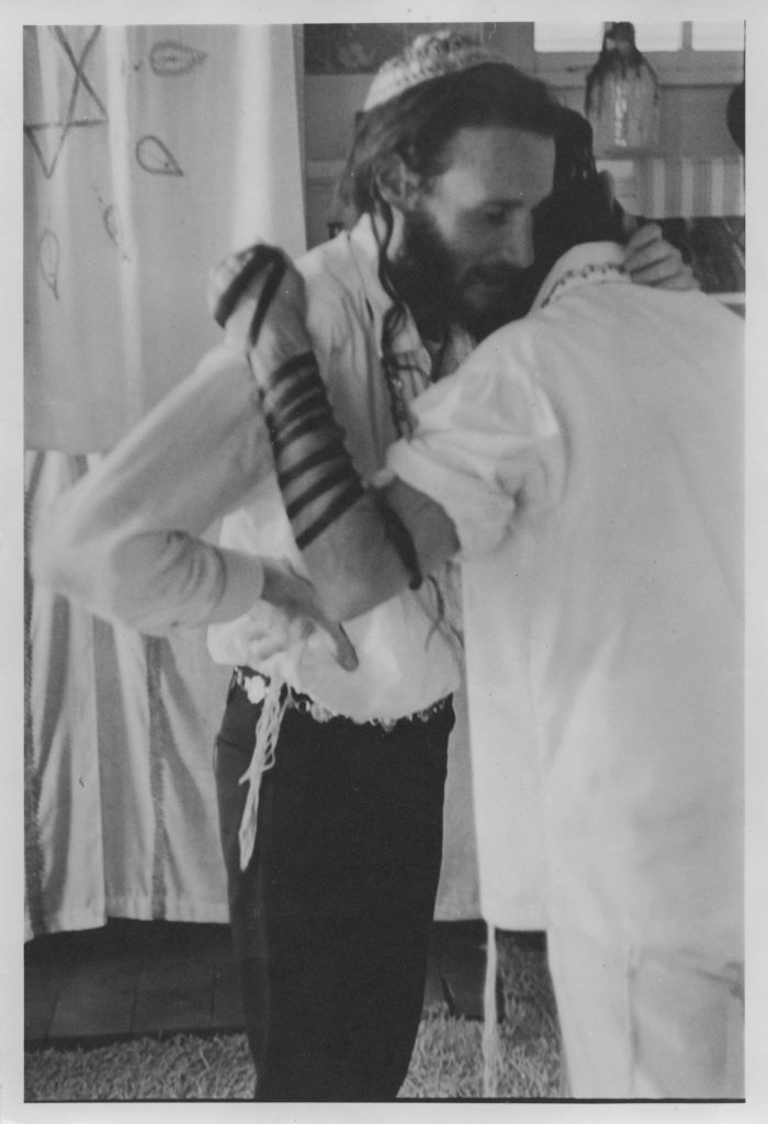 Elia Succot hugging George Gorner after helping him put on teffilin prior to his wedding. Photo by Marvin Kussoy, courtesy of Yehudit and Reuven Goldfarb.
